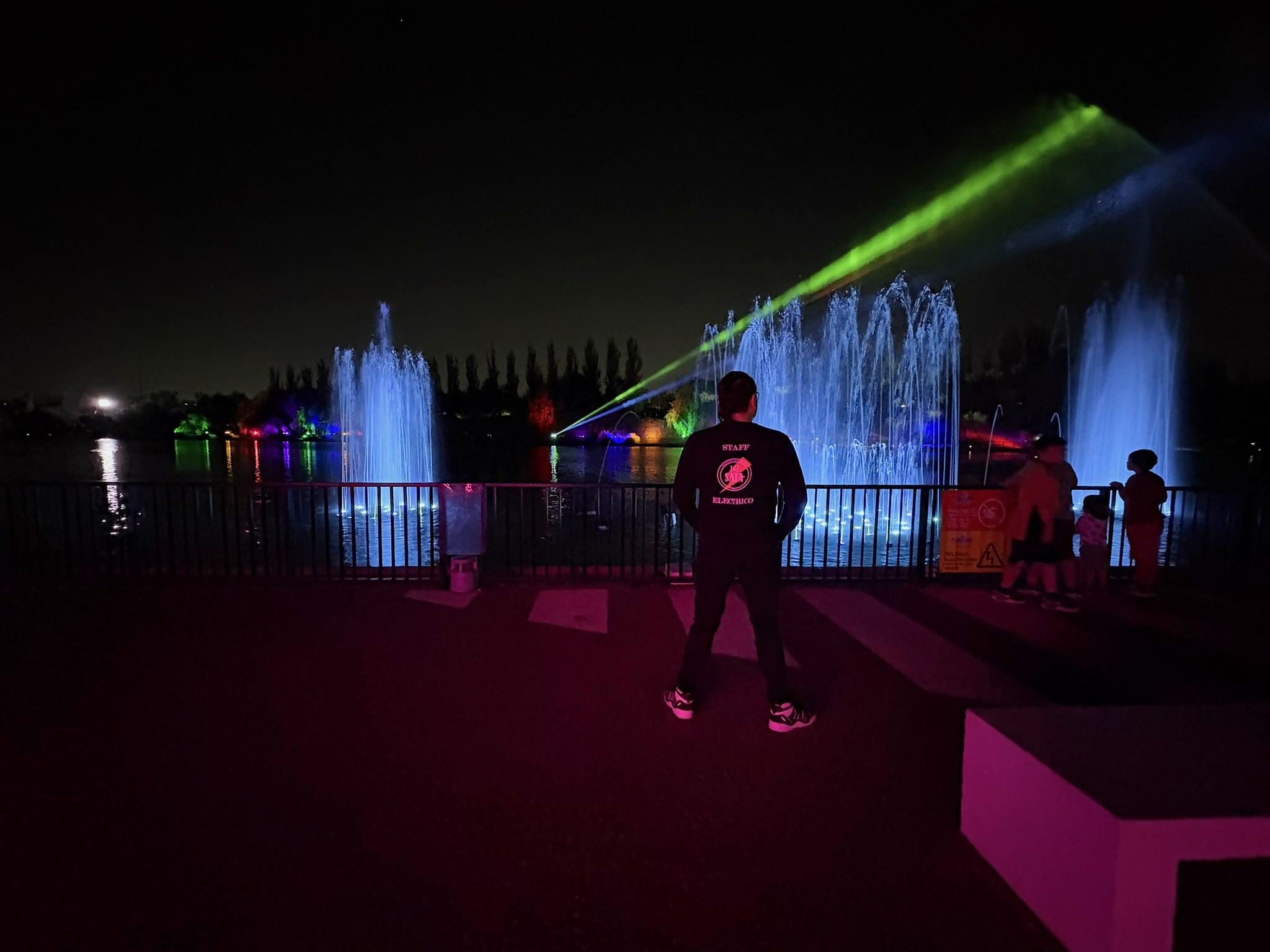 Técnico SATA frente a fuentes iluminadas y haces de luz en Parque Chino